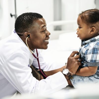 Cheerful pediatrician doing a medical checkup of a young boy